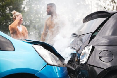 Is South Carolina a No-Fault State for Accidents | John Foy Two drivers stand next to their crashed cars, arguing about whether South Carolina is a no-fault state for accidents.