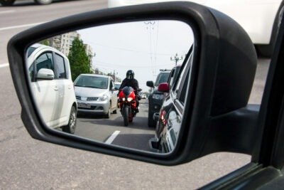 Does Car Insurance Cover Motorcycle Crashes? | John Foy A red motorcycle moves between lanes. Does car insurance cover motorcycle accidents?