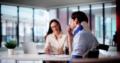 A man with a neck brace sits with his lawyer and asks about the personal injury damage caps in South Carolina.