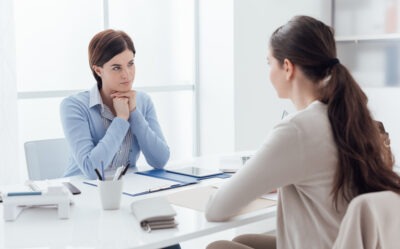 A woman sits at her lawyer’s desk and asks her, “What does a bicycle accident lawyer do?”