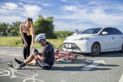 A driver checking on an injured cyclist while wondering about who is liable in a bike lane accident.