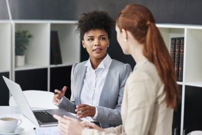 A lawyer sits at her desk and explains to her client that there is no difference between union and non-union workers’ compensation.