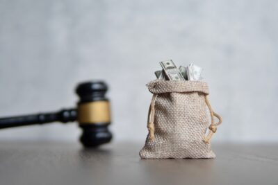Bag of money and judge's gavel. Lawsuit concept. What is a personal injury settlement agreement?
