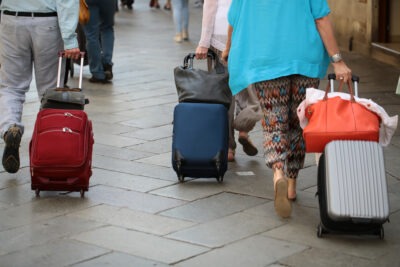 Family members holding rolling suitcases in preparation to travel on Thanksgiving Day
