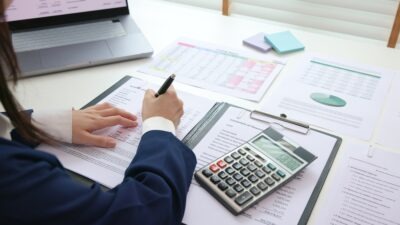 Person sitting at a desk with a calculator and financial documents in front of them and trying to figure out if a wrongful death settlement in South Carolina is taxable