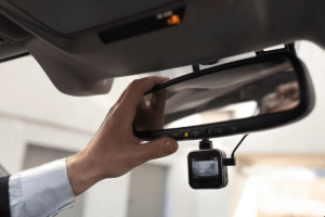 Man setting up a dashcam in his car